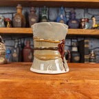 Three-quarter left side view of a handmade Scroll Mug designed to look like an old rolled parchment with a light grey base, a light brown ribbon, a dark brown cord and a dark red wax seal featuring a vampire emblem.