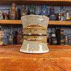 Back view of a handmade Scroll Mug designed to look like an old rolled parchment with a light grey base, a light brown ribbon and a dark brown cord.