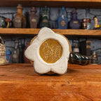 Bottom view of a handmade Coin Bag Mug with the 'Handy Goblin' logo embossed in the center, featuring a golden base with the visible bottom of the four fingers.