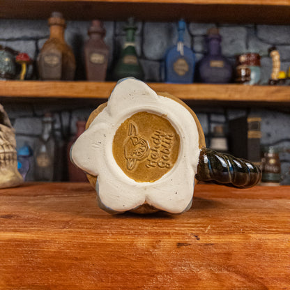 Bottom view of a handmade Coin Bag Mug with the 'Handy Goblin' logo embossed in the center, featuring a golden base with the visible bottom of the four fingers.