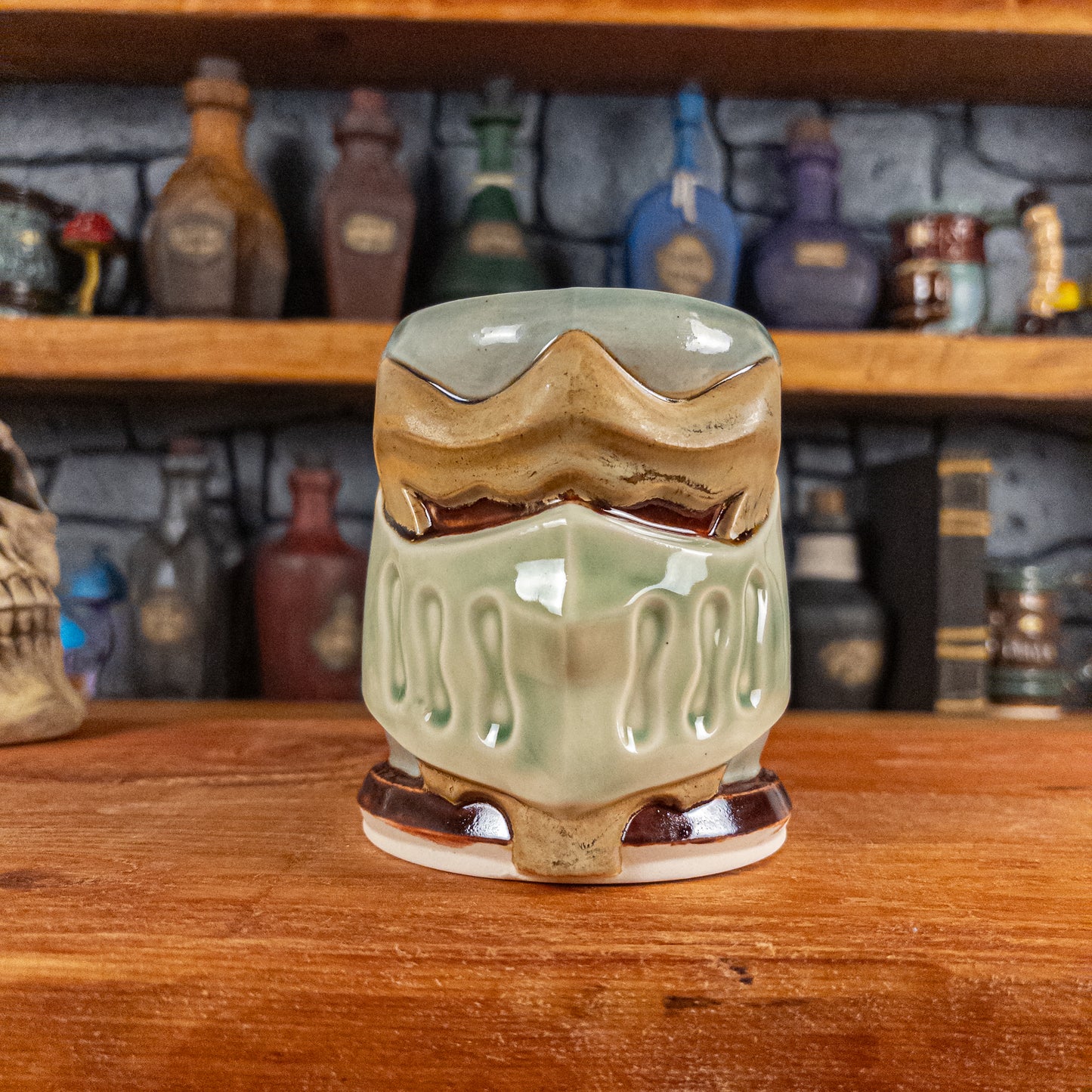 Front view of a handmade Knight Helmet Mug with a beige and semi-transparent green armour design and brown eye slits.