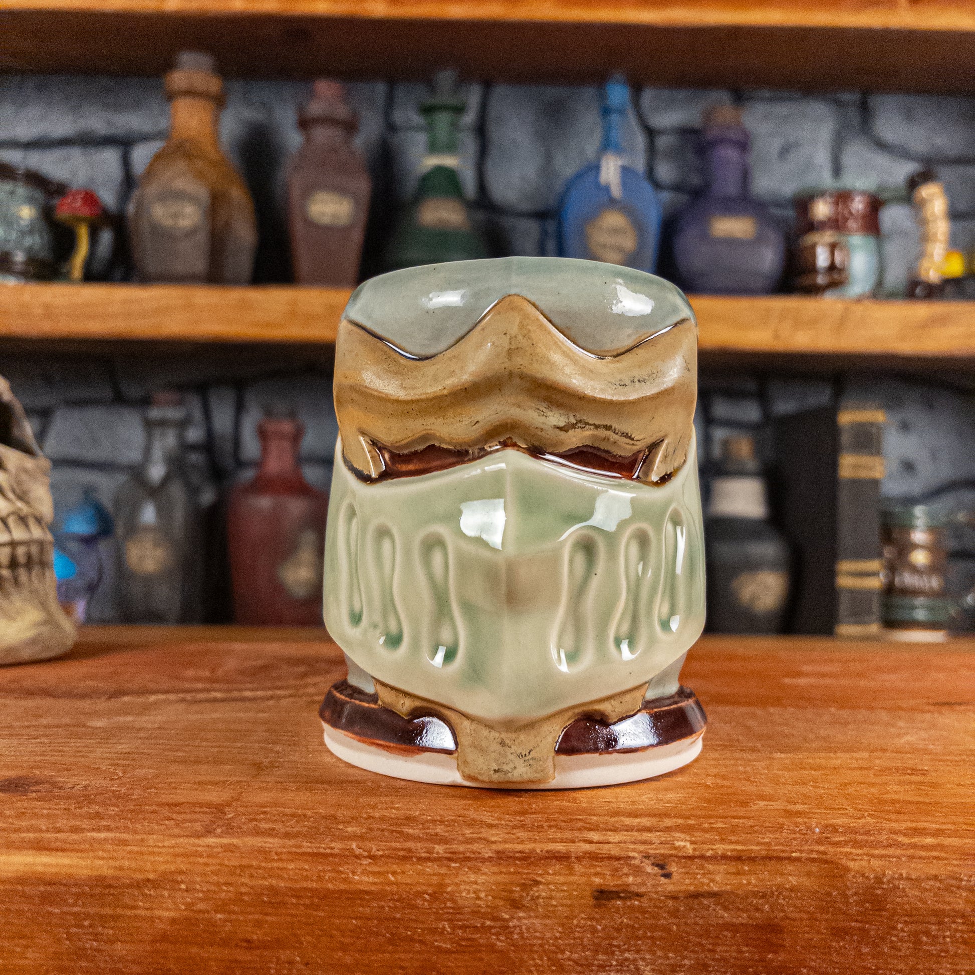 Front view of a handmade Knight Helmet Mug with a beige and semi-transparent green armour design and brown eye slits.
