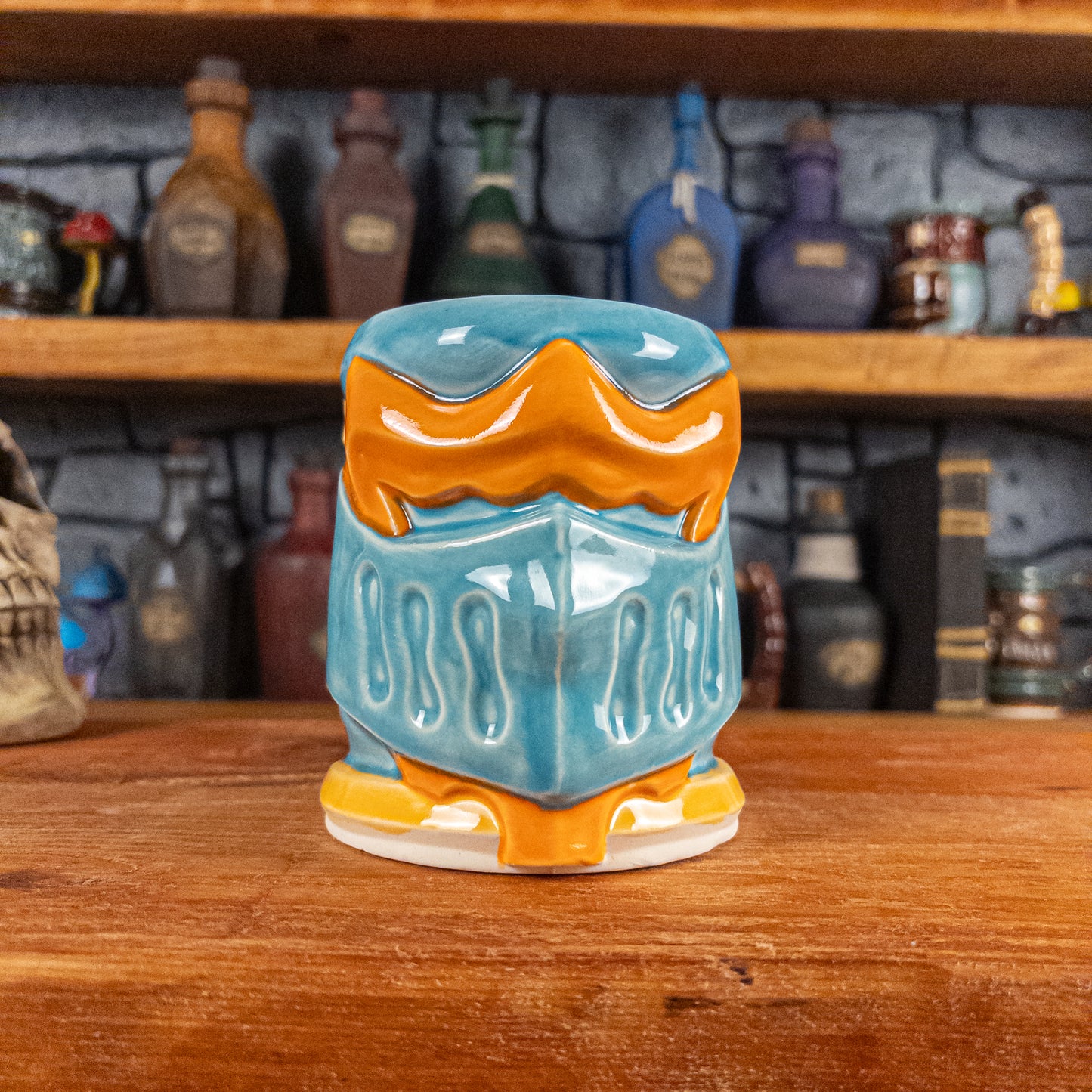 Front view of a handmade Knight Helmet Mug with a light blue and orange armour design.