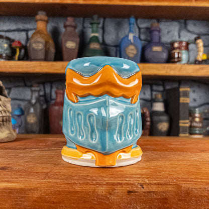 Front view of a handmade Knight Helmet Mug with a light blue and orange armour design.