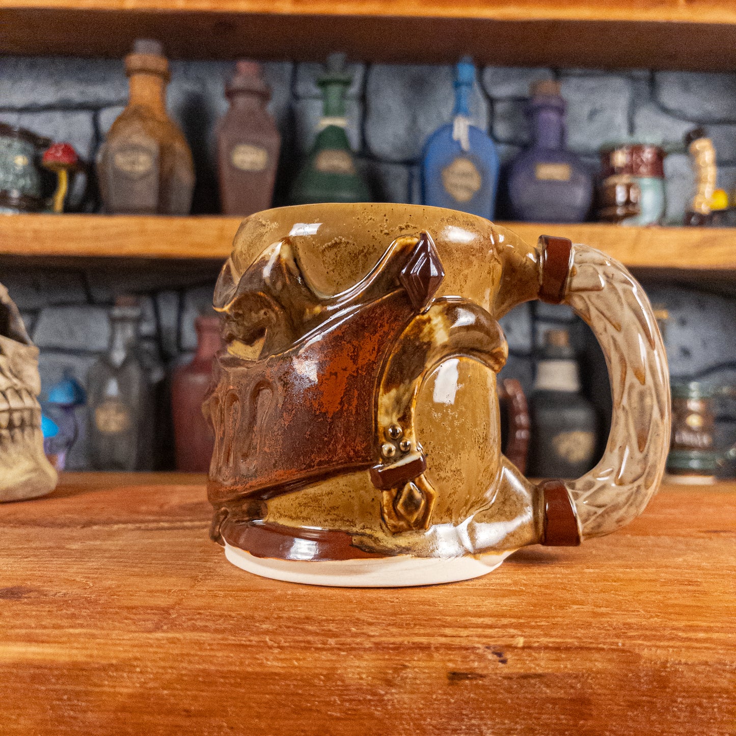 The right side view of a handmade Knight Helmet Mug with a brown and rusted armour design and brown eye slits, featuring ornamental rivets and a detailed sandy handle.
