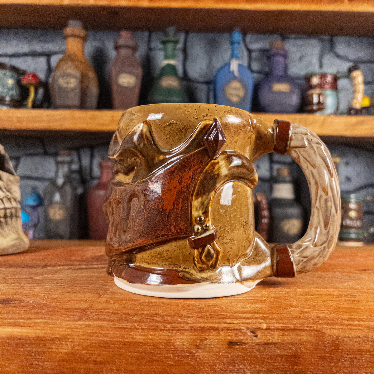 The right side view of a handmade Knight Helmet Mug with a brown and rusted armour design and brown eye slits, featuring ornamental rivets and a detailed sandy handle.