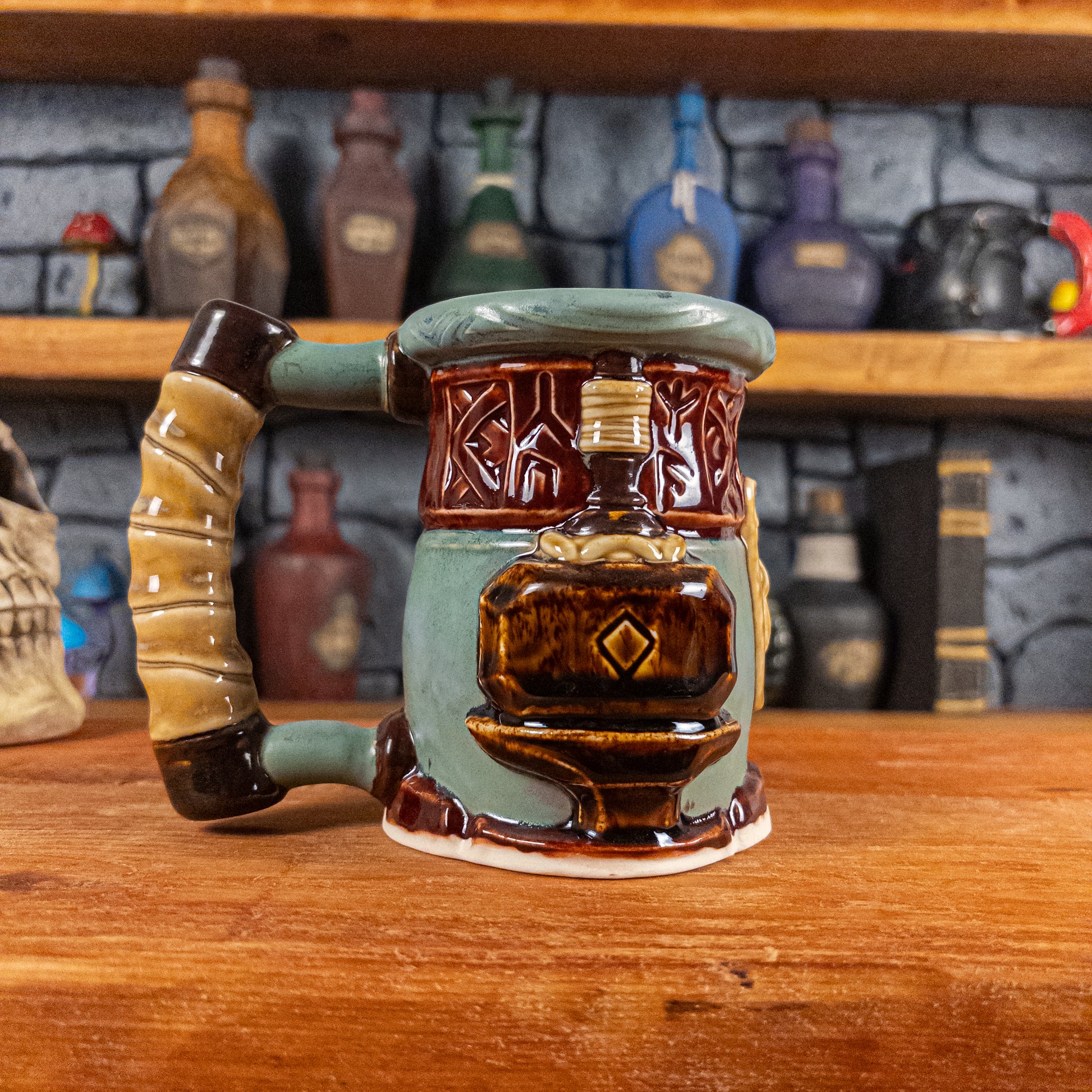 Left side view of a handmade Dwarven Mug designed to look like a greenish-blue and dark red barrel with intricate rune carvings, a partial dark beige dwarf face, and a hammer and anvil design, showing the detailed handle.