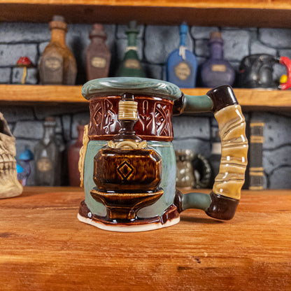 The right side view of a handmade Dwarven Mug designed to look like a greenish-blue and dark red barrel with intricate rune carvings, a partial dark beige dwarf face, and a hammer and anvil design, showing the detailed handle.