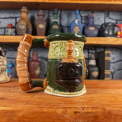 Left side view of a handmade Dwarven Mug designed to look like a light and dark green barrel with intricate rune carvings, a partial light brown dwarf face, and a hammer and anvil design, showing the detailed handle.