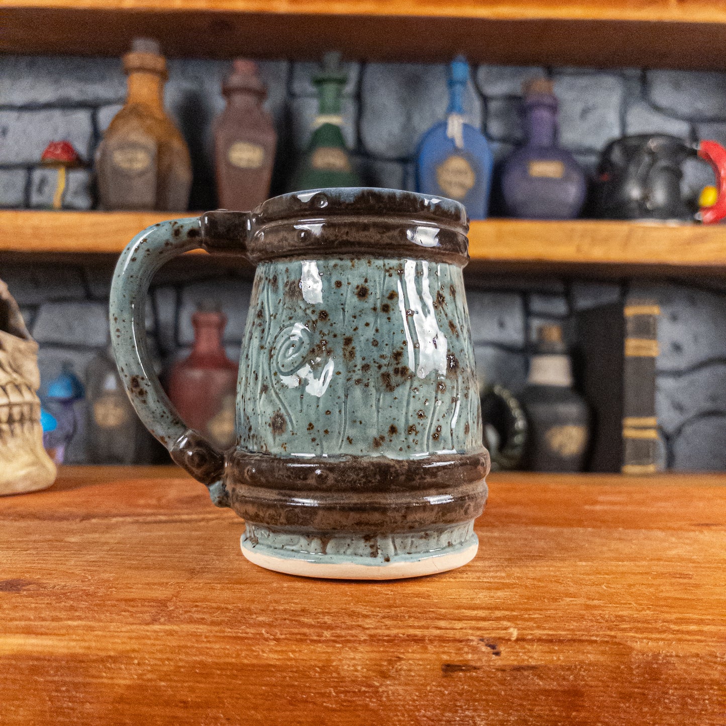 Back view of a handmade Mimic Mug designed to look like a speckled light blue wooden barrel with dark brown bands, showing the handle.