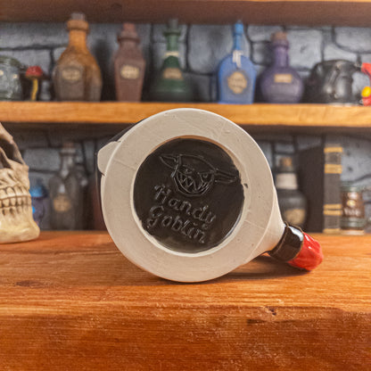Bottom view of a handmade Knight Helmet Mug with the Handy Goblin logo embossed in the centre, featuring a matte black base.