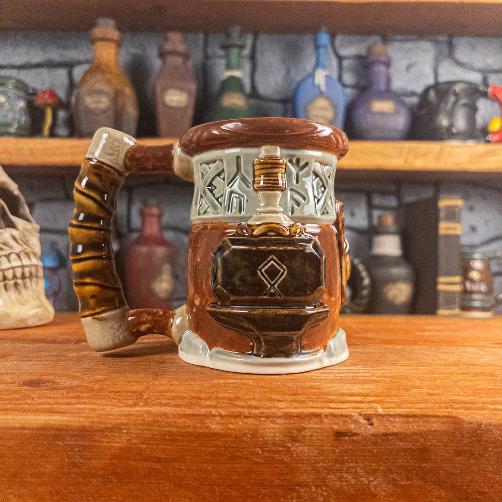 Left side view of a handmade Dwarven Mug designed to look like a light green and reddish-brown barrel with intricate rune carvings, a partial dwarf face, and a hammer and anvil design, showing the detailed handle.