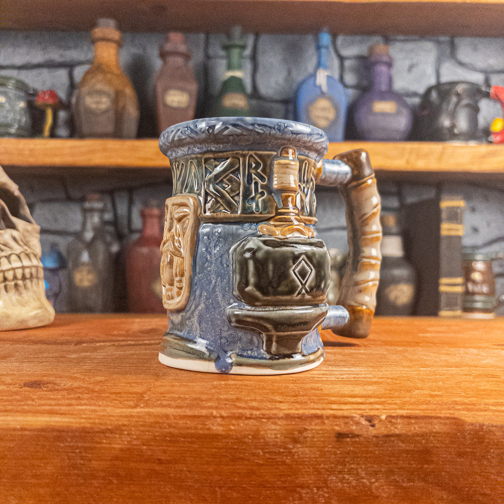 Three-quarter right side view of a handmade Dwarven Mug designed to look like a white-blue and brown-blue barrel with intricate rune carvings, a beige dwarf face, and a hammer and anvil design, showing the detailed handle.