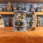 The right side view of a handmade Dwarven Mug designed to look like a white-blue and brown-blue barrel with intricate rune carvings, a partial beige dwarf face, and a hammer and anvil design, showing the detailed handle.
