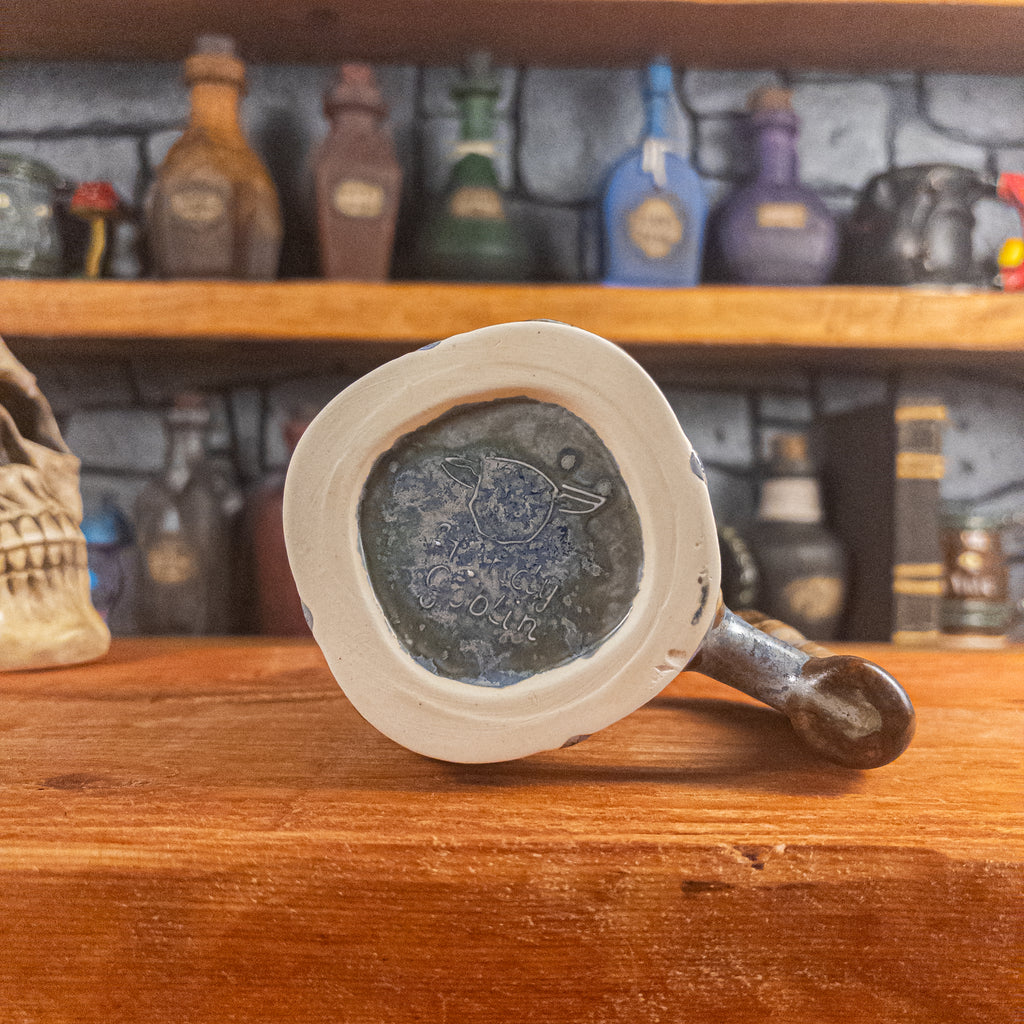 Bottom view of a handmade Dwarven Mug with the 'Handy Goblin' logo embossed in the center, featuring a white-blue base.